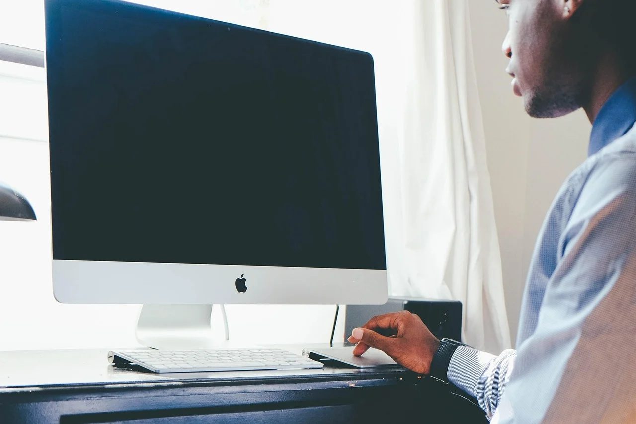 Person using a laptop to research SEO tools in a bright office